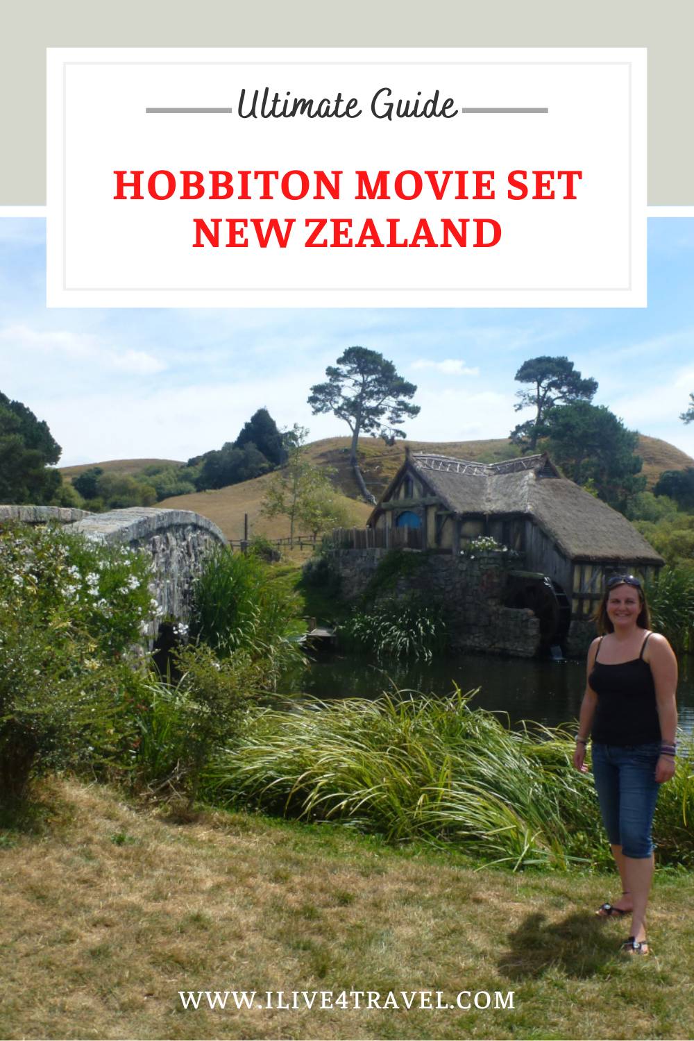 girl stood by a lake with a tudor style water mill in the background and a bridge crossing the lake and lots of green grass around