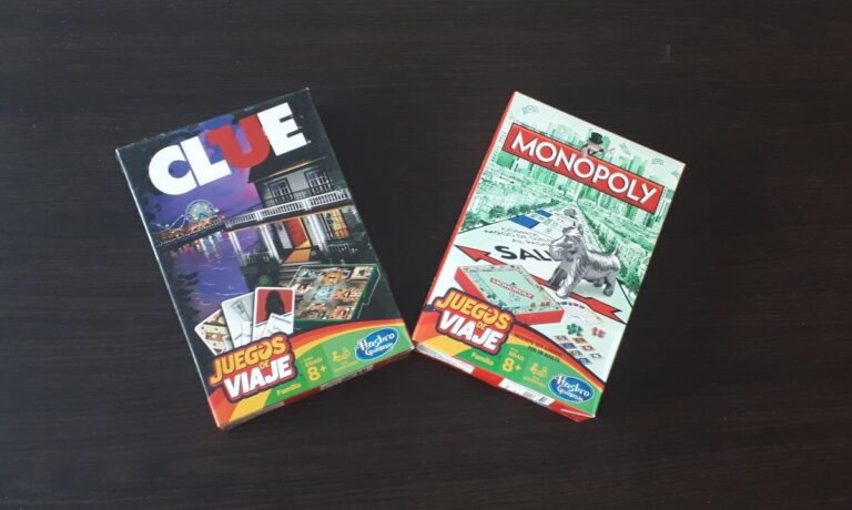 2 travel board games on a black background, the spanish version of cluedo and monopoly