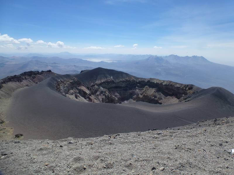 looking down from the summit of Misti Arequipa to a smaller active part of the volcano where you can see the black ash surrounding the centre of the volcano