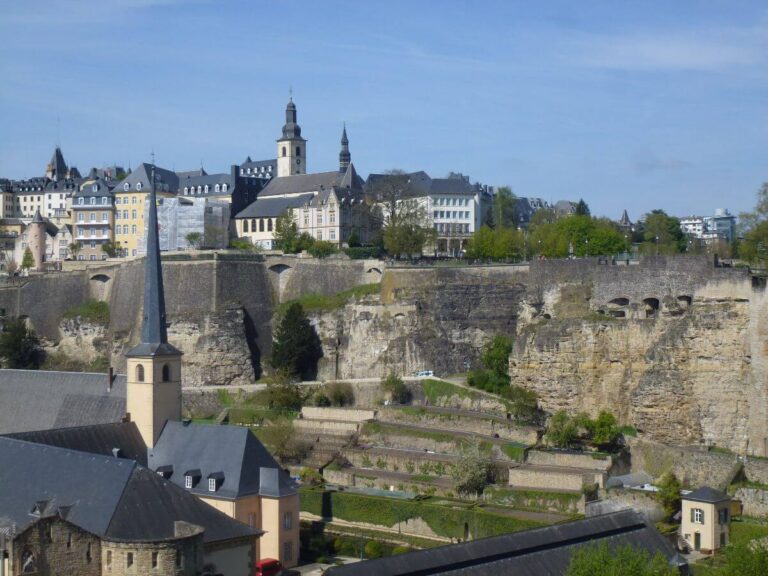a valley with some houses and a church in it, with buildings above it