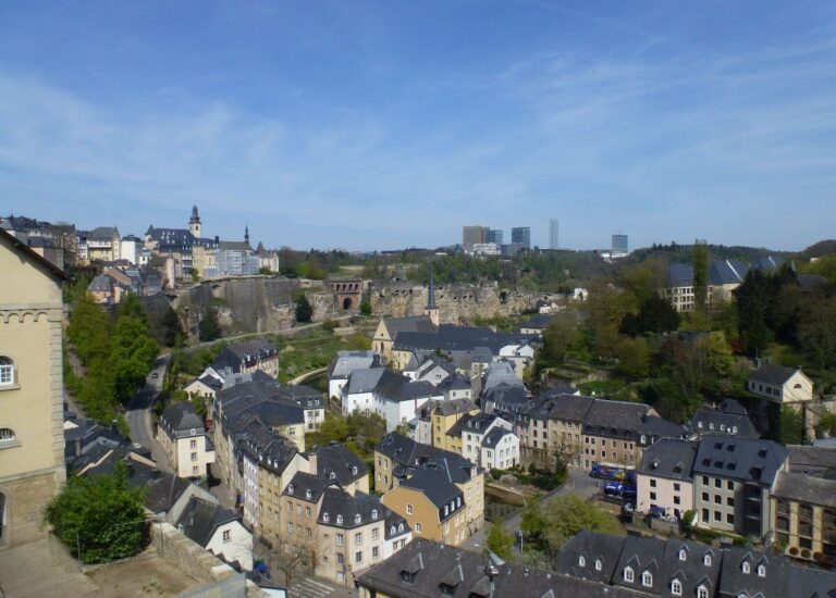 a valley with a river running through it and lots of buildings in it, also along the land on the top of it