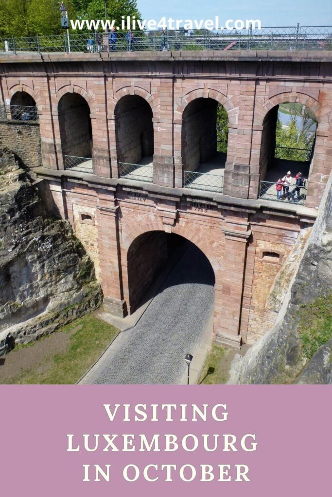 a pinterest pin about visiting luxembourg in October, with an image of an arch with a set of smaller arches above it made from brick