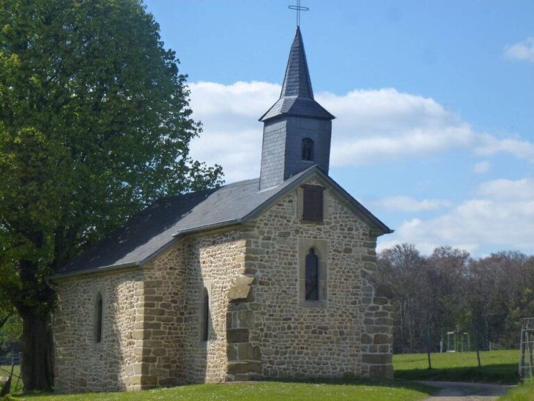 a church surrounded by trees and grass