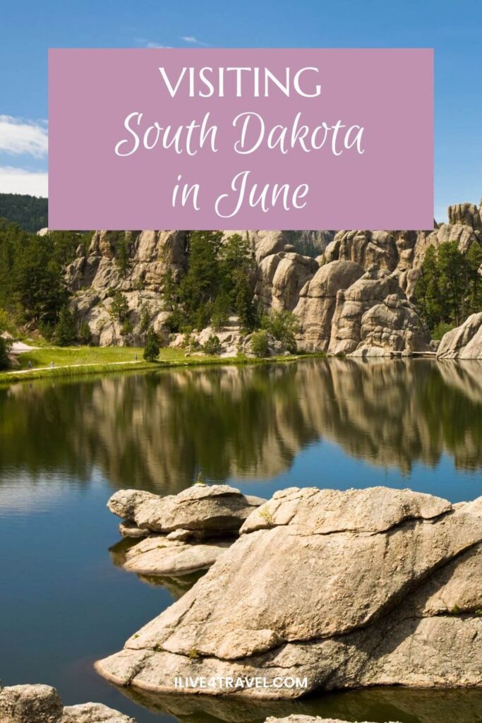 a pinterest pin about visiting south dakota in june showing a lake with grass and a path around it and huge boulders around parts of the edge too