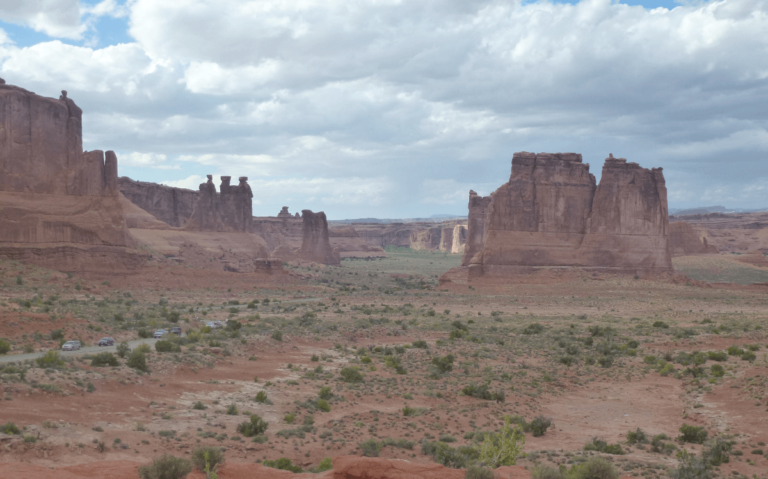 a flat valley with orange earth and some thin orange rocks that have been worn away