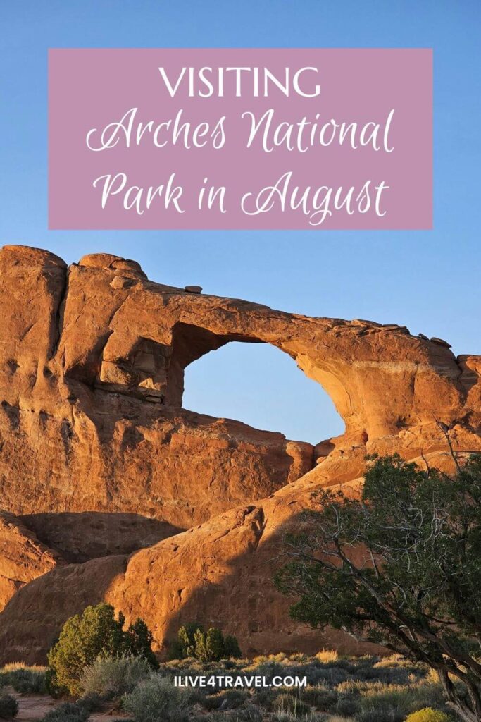 a pinterest pin about visiting arches national park in august, showing huge orange rocks with a hole in it with what looks like an arch at the top, with a tree and a few bushes on the ground